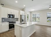 Thumbnail 1 of 71 - A kitchen with white cabinets and a stainless steel refrigerator.