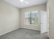 Thumbnail 9 of 71 - A room with a carpeted floor, a ceiling fan, and a window with blinds.