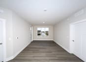 Thumbnail 11 of 31 - A long, empty hallway with white walls and a wooden floor.at Tiffany Flats, Columbus, OH, 43231