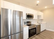 Thumbnail 8 of 31 - A modern kitchen with stainless steel appliances and white cabinets.at Tiffany Flats, Columbus