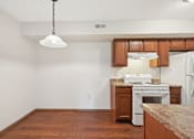 Thumbnail 18 of 41 - A kitchen with a white stove and wooden cabinets.