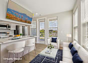 Thumbnail 9 of 30 - A living room with a white couch and a painting on the wall.