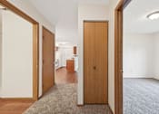 Thumbnail 8 of 41 - A hallway with a carpeted floor and a brown door.