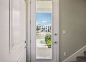 Thumbnail 10 of 71 - A white door with a glass window showing a street view.