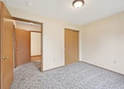 Thumbnail 38 of 41 - A room with a carpeted floor and two doors.