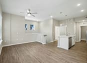 Thumbnail 8 of 71 - A spacious room with a kitchenette and a ceiling fan.