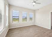 Thumbnail 14 of 71 - A room with a ceiling fan and three windows.