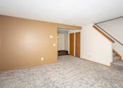 Thumbnail 2 of 21 - A room with a staircase and a door.