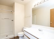 Thumbnail 11 of 23 - A white bathroom with a toilet, sink, and shower.