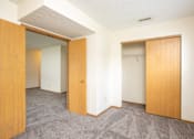 Thumbnail 22 of 24 - A room with two open doors and carpeted flooring.
