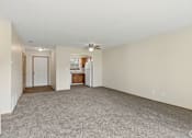 Thumbnail 15 of 28 - A spacious living room with a carpeted floor and a ceiling fan.