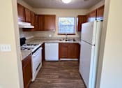 Thumbnail 12 of 24 - A kitchen with wooden cabinets and a white refrigerator.