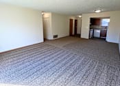 Thumbnail 6 of 24 - A large, empty room with a carpeted floor and white walls.