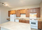 Thumbnail 1 of 23 - A kitchen with white appliances and wooden cabinets.
