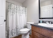 Thumbnail 6 of 23 - A white toilet sits next to a sink in a bathroom.