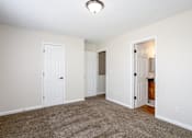 Thumbnail 7 of 23 - A room with white walls and a carpeted floor.