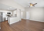 Thumbnail 1 of 28 - an empty living room with a kitchen and a ceiling fan