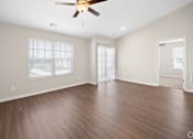 Thumbnail 2 of 28 - an empty living room with wood floors and a ceiling fan