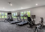 Thumbnail 8 of 57 - A spacious gym with treadmills and elliptical machines.
