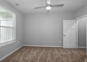 Thumbnail 51 of 57 - A room with a carpeted floor and a ceiling fan.