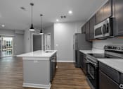 Thumbnail 56 of 57 - A modern kitchen with dark wood cabinets and stainless steel appliances.