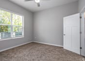 Thumbnail 55 of 57 - A room with a white door and a window with blinds.