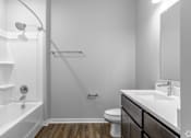 Thumbnail 52 of 57 - A white bathroom with a wooden floor and a white tub.