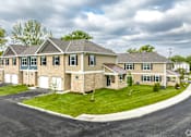 Thumbnail 36 of 57 - A row of houses with green lawns and trees in the background.