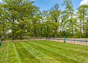 Thumbnail 43 of 57 - A green grassy field with trees in the background and a fence running along the edge.