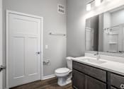 Thumbnail 57 of 57 - A white bathroom with a toilet, sink, and mirror.