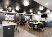 Thumbnail 46 of 57 - A modern dining area with a white counter and brown chairs.
