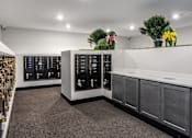 Thumbnail 50 of 57 - A room with a white ceiling and grey carpet, featuring a black and white cabinet with a digital display and a counter with a white surface.