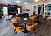 Thumbnail 10 of 16 - Clubhouse lounge area with seating, television, and fireplace at Greenwood Commons in Delaware, OH.