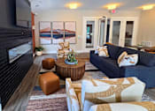 Thumbnail 11 of 16 - Clubhouse lounge area with seating, television, and fireplace at Greenwood Commons in Delaware, OH.