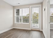 Thumbnail 16 of 33 - A room with a sliding glass door leading to a balcony.