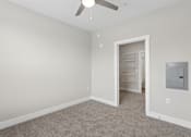 Thumbnail 18 of 33 - A room with a ceiling fan and a doorway leading to another room.