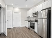Thumbnail 17 of 33 - A kitchen with white cabinets and stainless steel appliances.