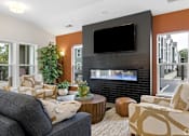 Thumbnail 4 of 33 - A living room with a grey couch, a black TV, and a fireplace.