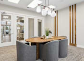 Thumbnail 14 of 33 - A modern dining room with a wooden table and grey chairs.