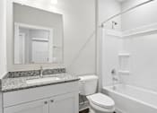 Thumbnail 24 of 33 - A white bathroom with a sink, toilet, and bathtub.