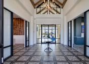 Thumbnail 43 of 49 - A large open hallway with a chandelier and a table in the middle.at Imperial Crossing Luxury Apartment Homes, Bonita Springs, FL