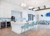 Thumbnail 49 of 49 - A kitchen with a white island and blue chairs.at Imperial Crossing Luxury Apartment Homes, Bonita Springs, FL