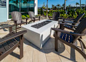 Thumbnail 17 of 49 - A patio with a fire pit and chairs.at Imperial Crossing Luxury Apartment Homes, Bonita Springs, FL, 34134