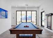 Thumbnail 48 of 49 - A pool table in a room with a view of the outside.at Imperial Crossing Luxury Apartment Homes, Bonita Springs, FL, 34134
