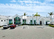 Thumbnail 9 of 49 - A parking lot with cars and a building in the background.at Imperial Crossing Luxury Apartment Homes, Florida
