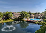 Thumbnail 5 of 22 - A fountain in the middle of a pond in front of a house.
