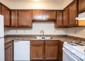 Thumbnail 32 of 32 - a kitchen with wood cabinets and white appliances and a sink