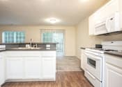 Thumbnail 14 of 17 - A kitchen with white appliances and cabinets.