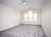 Thumbnail 10 of 17 - A room with a ceiling fan and carpeted floor.