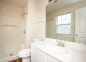 Thumbnail 7 of 17 - A white bathroom with a toilet, sink, and bathtub.